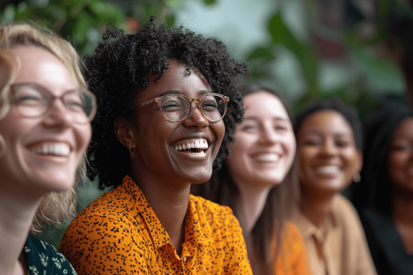 A cheerful gathering of women, all smiling and laughing, sharing a happy moment together.